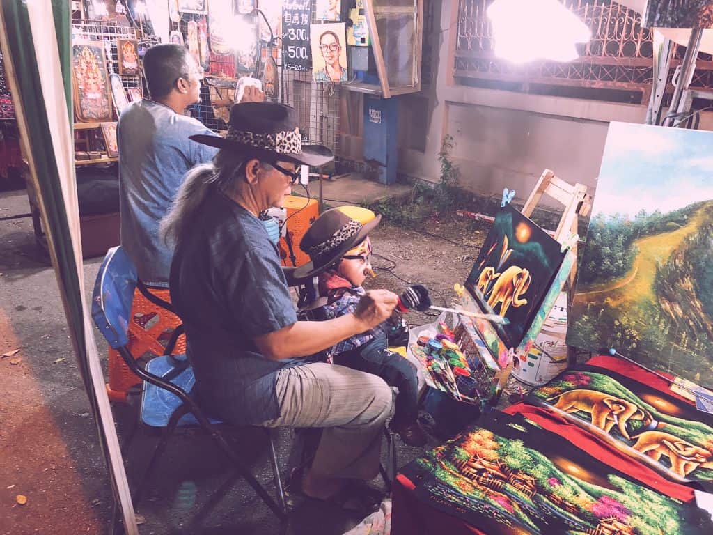 Man painting with a puppet at a Chiang Mai Market